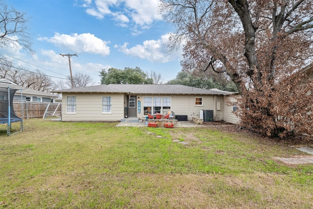 back of house with central AC, a yard, a patio area, and a trampoline