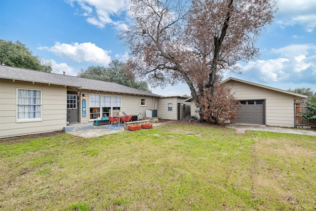 rear view of house with a garage, a patio, and a lawn