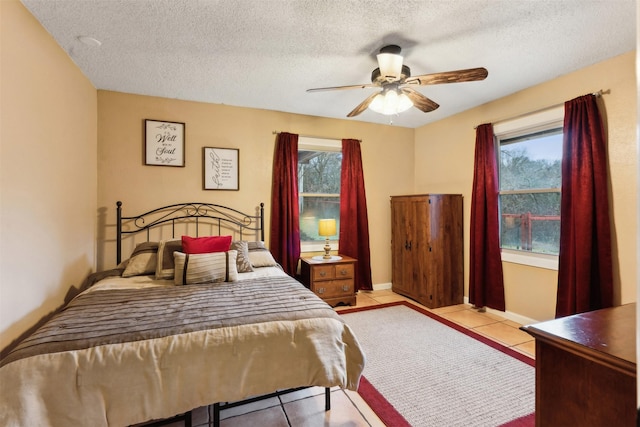 tiled bedroom featuring ceiling fan and a textured ceiling