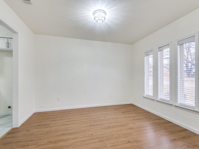 empty room with light hardwood / wood-style flooring