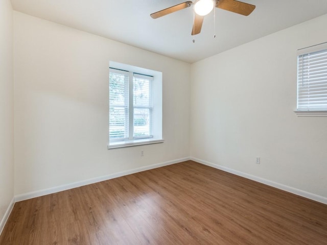 empty room with hardwood / wood-style floors and ceiling fan