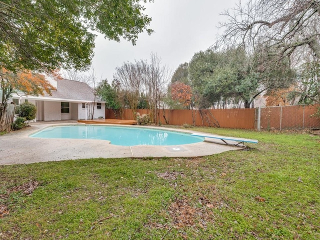 view of swimming pool featuring a diving board and a yard