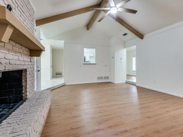 unfurnished living room with lofted ceiling with beams, ceiling fan, a fireplace, and light hardwood / wood-style floors