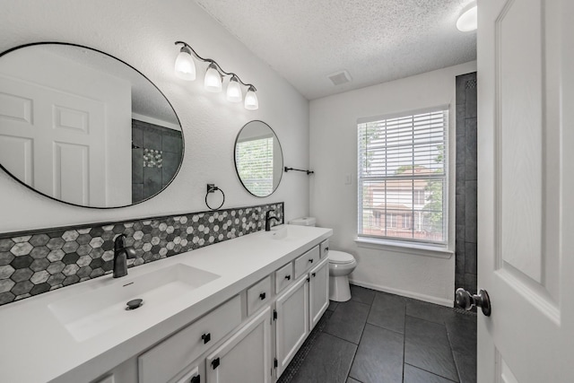 full bath featuring a textured ceiling, double vanity, a sink, and tile patterned floors