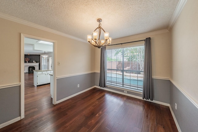 empty room with a textured ceiling, an inviting chandelier, ornamental molding, and dark wood-style flooring