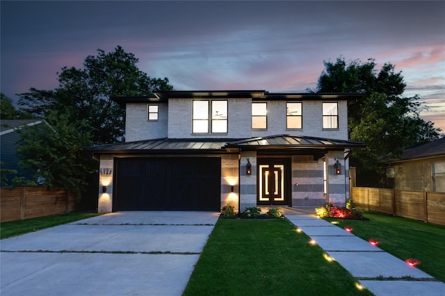 view of front of home with fence, an attached garage, driveway, and a standing seam roof