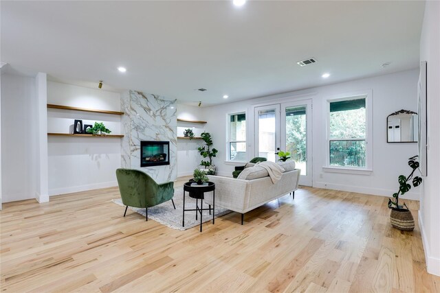 kitchen with high end appliances, white cabinets, light stone counters, and decorative light fixtures