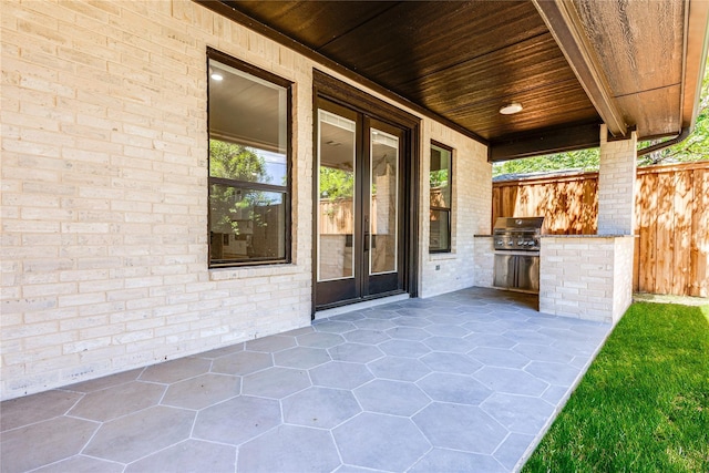 view of patio / terrace with french doors, an outdoor kitchen, and a grill