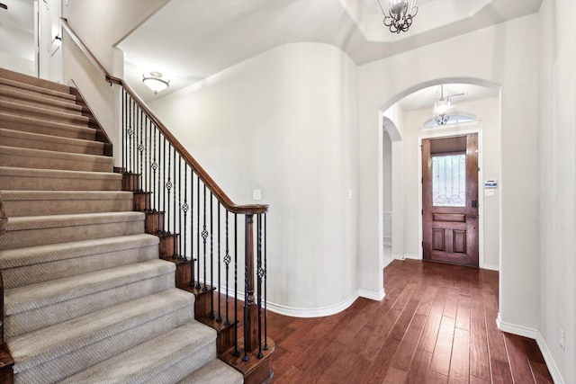 foyer featuring an inviting chandelier and dark hardwood / wood-style flooring