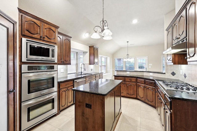 kitchen featuring pendant lighting, an inviting chandelier, stainless steel appliances, a center island, and kitchen peninsula