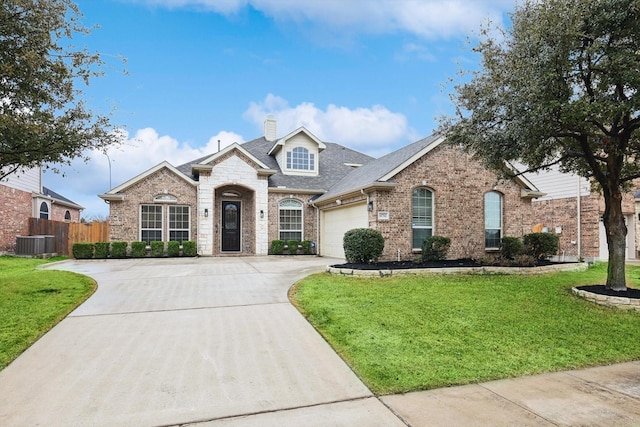 view of front of home with cooling unit, a garage, and a front yard