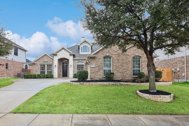 view of front of home with central AC and a front lawn