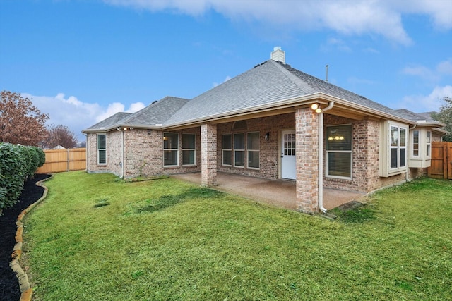 back of property with a yard and a patio area