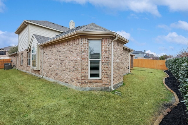 view of side of property featuring a yard and central air condition unit