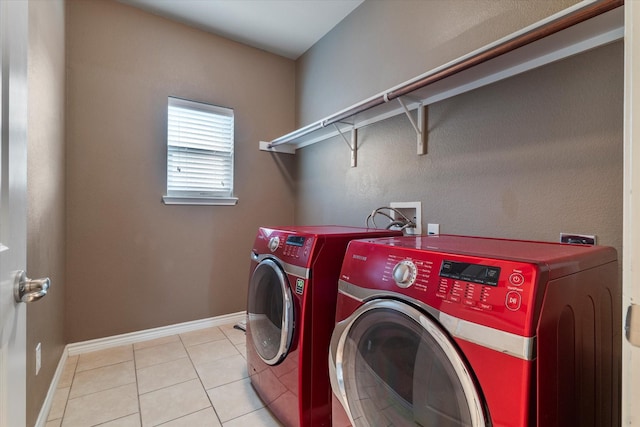 clothes washing area with washer and dryer and light tile patterned floors