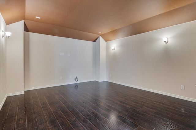 unfurnished room with vaulted ceiling and dark hardwood / wood-style flooring