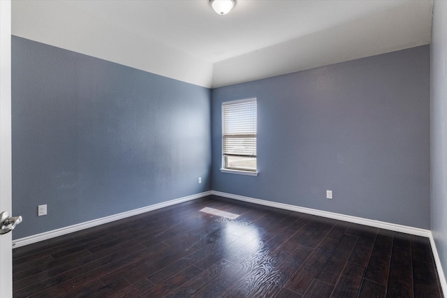 unfurnished room featuring dark wood-type flooring and vaulted ceiling