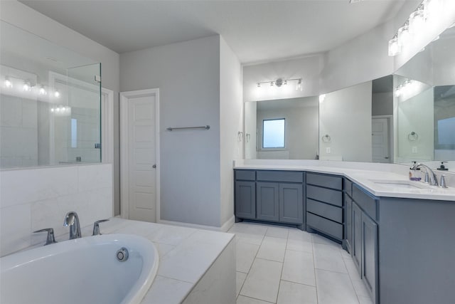 bathroom with vanity, tile patterned flooring, and tiled tub