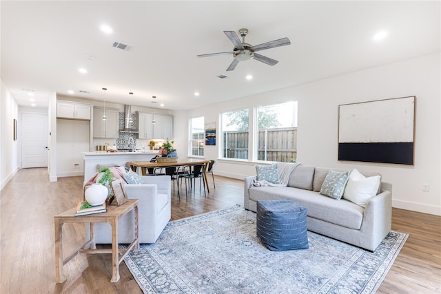 living room featuring ceiling fan and light wood-type flooring