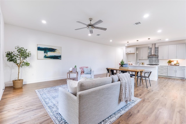 living room with ceiling fan and light wood-type flooring