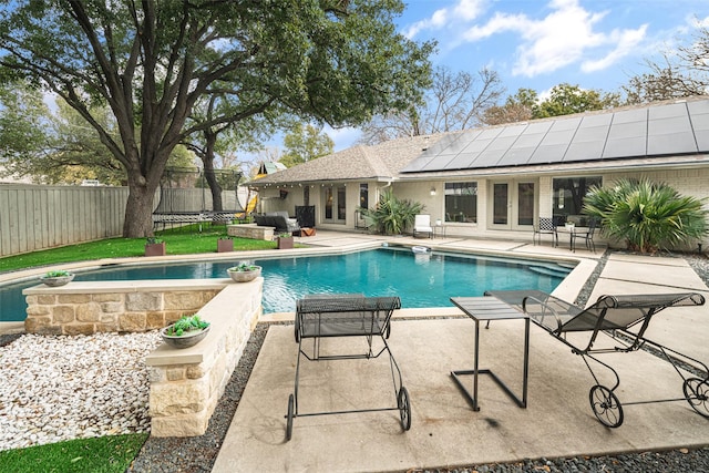 view of swimming pool featuring a trampoline and a patio