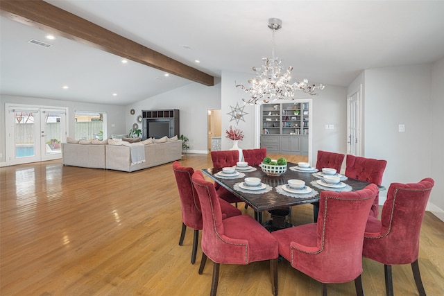 dining area featuring lofted ceiling with beams, a notable chandelier, light hardwood / wood-style floors, and french doors