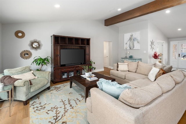 living room with light hardwood / wood-style floors and lofted ceiling with beams