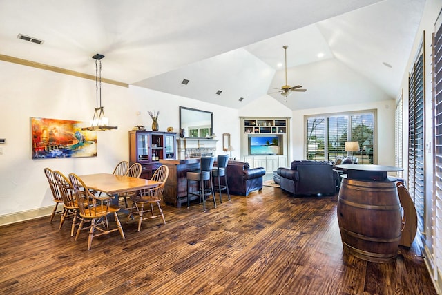 dining space with dark hardwood / wood-style floors, ceiling fan with notable chandelier, and high vaulted ceiling