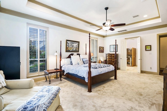 carpeted bedroom featuring crown molding, ceiling fan, and a raised ceiling