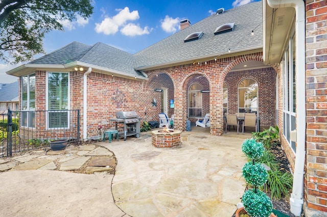 view of patio with area for grilling and a fire pit