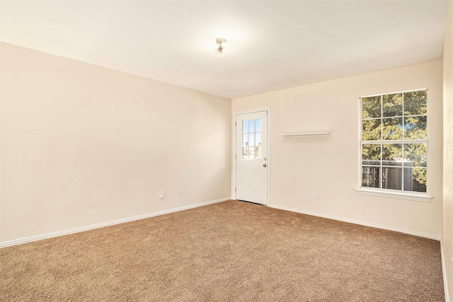 carpeted spare room featuring a healthy amount of sunlight