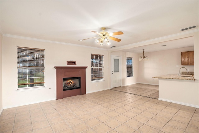 unfurnished living room featuring crown molding, sink, ceiling fan with notable chandelier, and light tile patterned floors