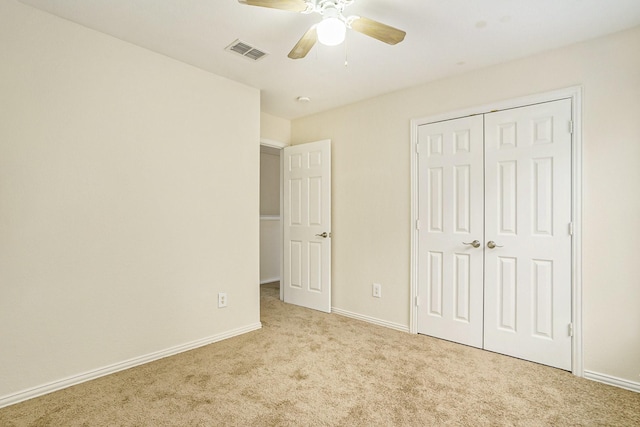 unfurnished bedroom featuring ceiling fan, a closet, and light carpet