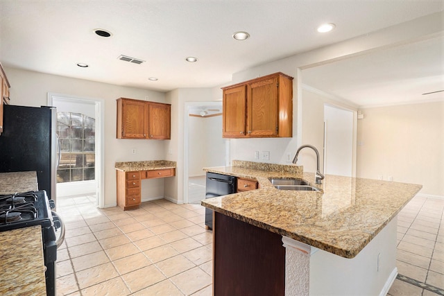 kitchen featuring sink, stainless steel refrigerator, dishwasher, range with gas stovetop, and light stone countertops