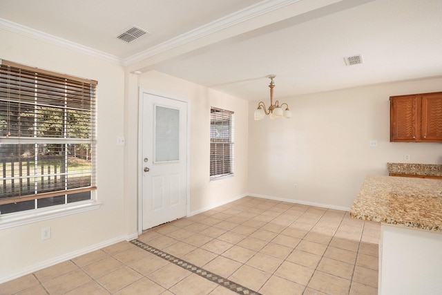 unfurnished dining area featuring crown molding, light tile patterned floors, and a notable chandelier