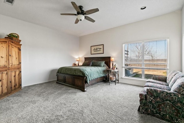 bedroom featuring a textured ceiling, light colored carpet, and ceiling fan