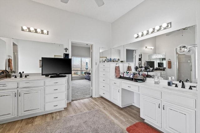 bathroom featuring ceiling fan, wood-type flooring, vanity, and lofted ceiling