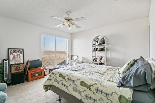 carpeted bedroom with ceiling fan and a textured ceiling