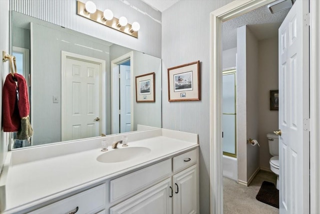 full bathroom with vanity, combined bath / shower with glass door, and toilet