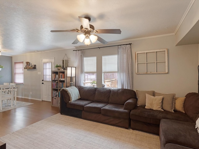 living room featuring ornamental molding, plenty of natural light, ceiling fan, and dark hardwood / wood-style flooring