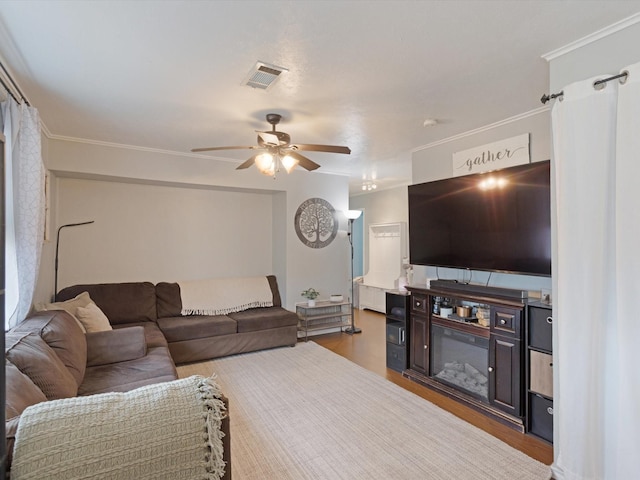 living room featuring crown molding, hardwood / wood-style flooring, and ceiling fan