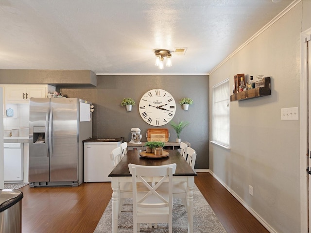 dining room featuring ornamental molding and dark wood-type flooring