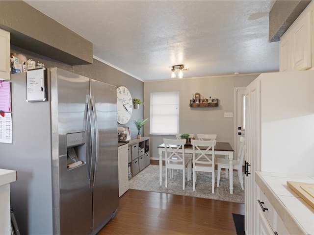 kitchen featuring white cabinetry, dark hardwood / wood-style floors, tile counters, and stainless steel fridge