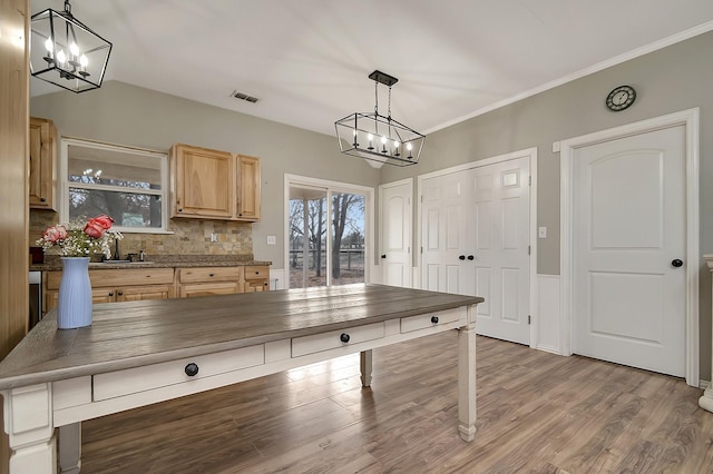 kitchen featuring pendant lighting, sink, backsplash, light brown cabinets, and light wood-type flooring