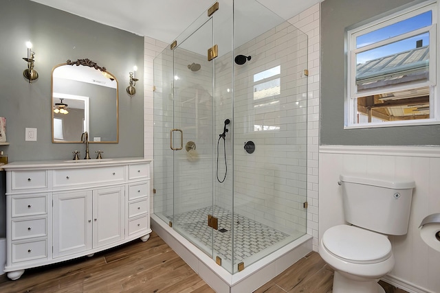 bathroom with vanity, wood-type flooring, a shower with door, and toilet