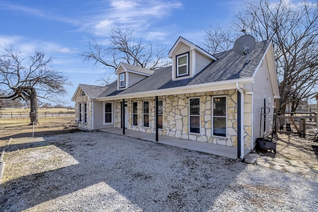 cape cod house featuring covered porch