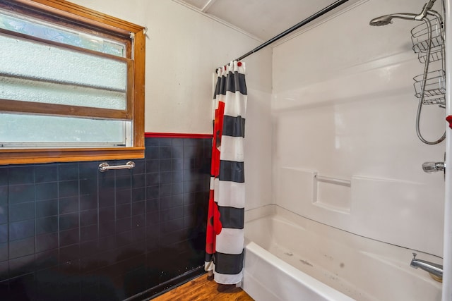 bathroom with tile walls, wood-type flooring, and shower / bath combo