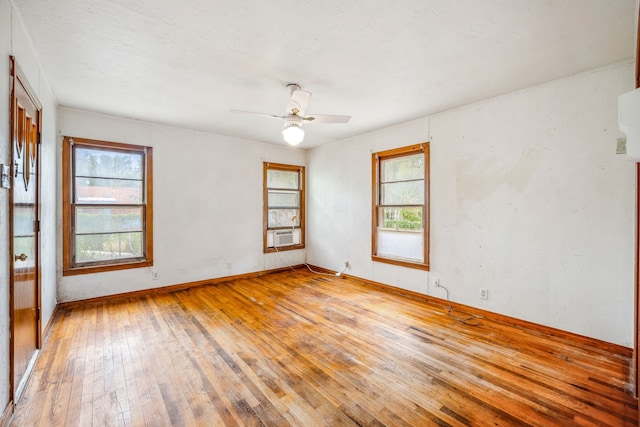 unfurnished room with ceiling fan, cooling unit, and light wood-type flooring