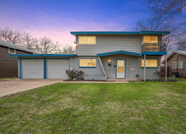 view of front of house featuring a balcony, a garage, and a yard