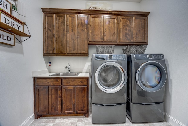 laundry area featuring cabinets, sink, and washer and clothes dryer